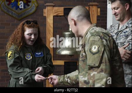 Fallon Emery, ein neues Ehrenmitglied der 437th Operations Support Squadron, übernimmt eine Herausforderung Münze von Chief Master Sgt. Ronnie Phillips, 437Th Airlift Wing command Chief Master Sergeant, Nov. 7, 2018, in gemeinsamen Basis Charleston, S.C., als Teil der Pilot für einen Tag Programm. Während ihres Besuchs wird die 14-jährige Emery met mit Phillips und Oberst Clint ZumBrunnen, rechts, 437Th AW Commander, bereiste eine C-17 Globemaster III Flugzeuge und Flight Simulator, night vision und andere militärische Technologie gelernt und gesteuert eine Beseitigung von Explosivstoffen Roboter. Schmirgel kämpft ein glioblastom Mu. Stockfoto