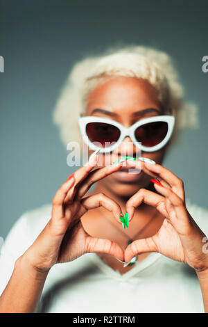 Gestik Portrait cool junge Frau Herz - Zeichen mit den Händen Stockfoto