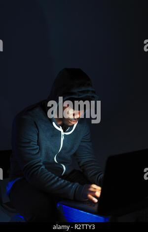 Teenager in Hoody am Laptop Stockfoto