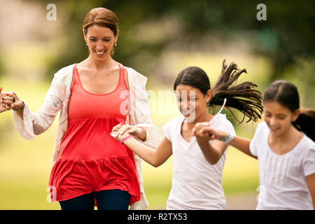 Reife Frau Spaß zu Fuß und Hand in Hand mit ihren Töchtern. Stockfoto
