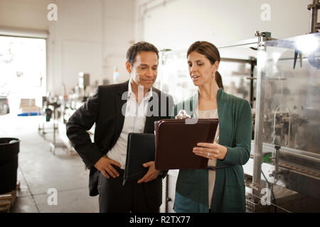 Kolleginnen und Kollegen diskutieren, arbeiten in einer Fabrik. Stockfoto