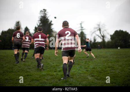 Männer spielen Rugby auf einem Sportplatz. Stockfoto