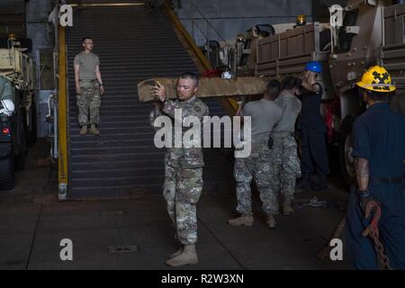 Gewässern vor der Küste von SAIPAN (Nov. 12, 2018) Soldaten aus dem 9. Mission unterstützt den Befehl, 411 Engineer Brigade, Guam Army National Guard bewegen Traggerüst aus dem gut Deck des Amphibischen dock Landung Schiff USS Ashland (LSD 48), wie das Schiff für Landing Craft, Utility (LCU) Operationen bereitet schwere Ausrüstung auf der Insel Saipan für Verteidigung Unterstützung der zivilen Behörden (DSCA) Anstrengungen zu bewegen. Matrosen und Marines von Ashland, Commander, Amphibischen Squadron 11 vergeben werden, sind die Verteidigungsministerium Unterstützung des Commonwealth von zivilen und lokalen Büros der Nördlichen Marianen' Stockfoto