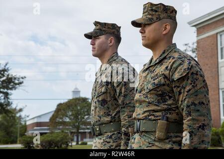 Us Marine Corps Cpl. Christopher L. Canup, Links, juristische Sekretärin, und Kapitän John T. Miller, Assistant Operations Officer, Sitz und Unterstützung Bataillon, Marine Corps Installationen Ost, Marine Corps Base Camp Lejeune, stehen an Aufmerksamkeit während der Glocken des Friedens Zeremonie an John A. Lejeune Halle auf MCB Camp Lejeune, N.C., Nov. 11, 2018. Die Glocken des Friedens ist eine nationale Veranstaltung für die 116,516 Amerikaner, die starben und über 200.000 waren im Großen Krieg verletzte Ehre. Stockfoto