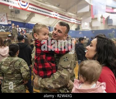 Sgt. Andrew Tymez, der 2 Infantry Brigade Combat Team zugeordnet, 4 Infanterie Division, hält sein Sohn, Wesley, als er mit seiner Familie vereint folgende Ein homecoming Zeremonie, William Bill Reed Special Event Center, Fort Carson, Colo., Nov. 13, 2018. Die 2 IBCT, 4. Inf. Div. Bereitgestellt im Februar nach Afghanistan die entschlossene Unterstützung der Durchführung von Zug, beraten und Maßnahmen, die es ermöglichen, der afghanischen nationalen Verteidigungs- und Sicherheitskräfte Sicherheit und Stabilität zu erhöhen, um die terroristischen sicheren Häfen zu verhindern, unterstützen. Zusätzlich ein Bataillon bereitgestellt für den Kosovo zur Unterstützung der Stockfoto