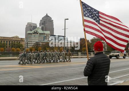 Flieger der 121 Luftbetankung Flügel März letzten Zuschauer winkten amerikanische Flaggen als Teil der jährlichen Veterans Day Parade, Nov 9, 2018, in Columbus, Ohio. Mehr als 50 Mitglieder des Ohio Armee und Air National Guard unterstützte die Veranstaltung, einschließlich der Color Guard, Fahrzeuge, die 122 Army Band und Demonstranten. Die diesjährige Parade gefeiert wird das 100-jährige Jubiläum des Ersten Weltkrieges Waffenstillstand und der amerikanischen Legion Centennial. Stockfoto