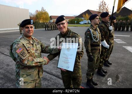 Us-Armee Oberst Neil Khatod, Kommandant der 2d Theater Signal Brigade, präsentiert eine Partnerschaft Zertifikat Bundeswehr Oberstleutnant Marc Richter, Kommandant der Bundeswehr 293 ES Bataillon, während einer Zeremonie, die Partnerschaft zwischen der 52d strategisches Signal und das Bataillon der Trainerwechsel es Bataillon, Nov. 8, 2018, in Murnau, Deutschland zu formalisieren. Stockfoto