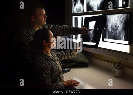 Senior Flieger Joseph Broyles und Sarai Eastman, 341 medizinische Unterstützung Squadron diagnostische Bildgebung Technologen, untersuchen, Röntgenstrahlen, die in der Klinik Nov. 6, 2018, in der malmstrom Air Force Base, Mont Nach dem Techniker der X-Strahlen für die Richtigkeit überprüfen Sie die Bilder mit dem Radiologen bei der Air Force Academy zur weiteren Prüfung senden. Stockfoto