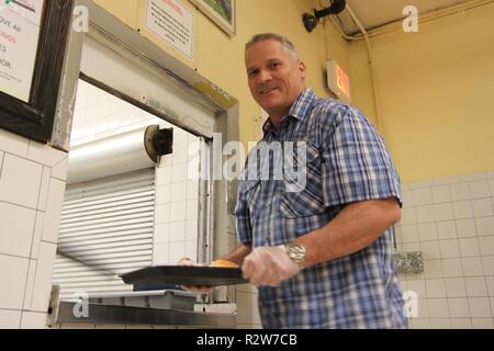 U.S. Army Reserve Staff Sgt. Richard Midkiff aus der zweiten Bataillon, 379 Regiment, in Brookline, Arche, bietet Unterstützung für die lokale Gemeinschaft durch Freiwilligenarbeit in seiner freien Zeit essen, die den in der Rescue Mission von Trenton, New Jersey, Okt. 30, 2018 dienen. Stockfoto