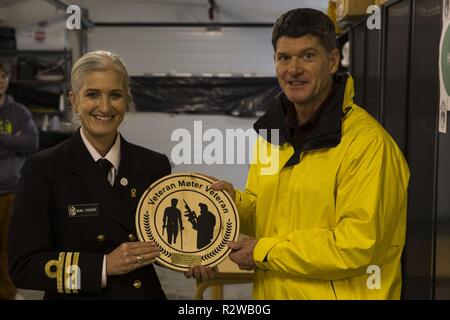 Cmdr. Frederikke Lysgaard, Links, präsentiert Lt.Cmdr. Harold Waldmeister mit einer Plakette der Wertschätzung an die Veteranen Moter Veteranen nach Hause in Oslo, Norwegen November 15, 2018. Marinesoldaten und Matrosen mit dem 24 Marine Expeditionary Unit und USS Iwo Jima (LHD7) im allgemeinen Wartung unterstützt, ein Spielzeug gebaut Regal und Beziehungen zu den norwegischen Veteranen. Lysgaard ist ein Verbindungsbeamter mit der norwegischen Marine und Waldmeister ist der Kaplan für die 24 MEU. Stockfoto