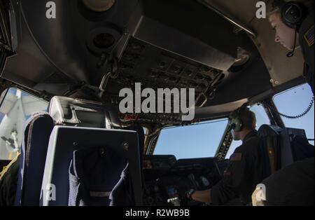Oberstleutnant Kevin Holz und Oberstleutnant Kenneth Dixon, Piloten auf den 9 Airlift Squadron, Dover Air Force Base, Del zugeordnet, bis eine C-5 M Super Galaxy für eine inflight Betankung mit einer KC-135 Stratotanker während ein Mitglied der 142 Aeromedical Evacuation Squadron, California Air National Guard, an November 8, 2018 beobachtet. Die Ausbildung sortie unterstützt auch 142 AE Inflight medical Szenario Training. Stockfoto