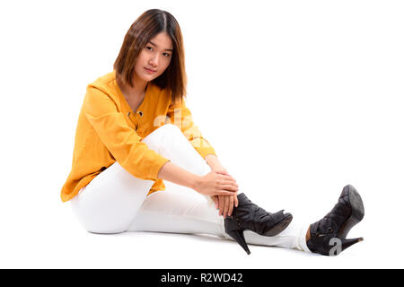 Studio shot der jungen schönen asiatischen Frau sitzt auf dem Boden Stockfoto