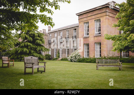 Cambridge, UK - Februar, 2019. Leere Bänke im Garten des Downing College, ein konstituierendes College der Universität Cambridge. Stockfoto