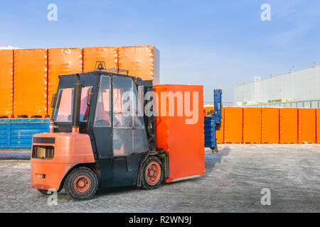 Gabelstapler Entladen von LKW-Auflieger mit verpackten Kartons im Freien. openair Lager arbeitet im Hintergrund. Stockfoto