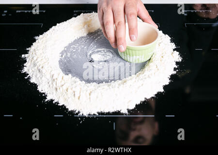 Koch prepairing frische Pasta Teig auf einer schwarzen Oberfläche Stockfoto