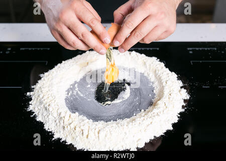 Koch prepairing frische Pasta Teig auf einer schwarzen Oberfläche Stockfoto