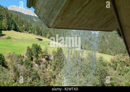 Tiroler Alpenlandschaft wie durch einen Vorhang aus Wasser hinter einem Wasserfall gesehen. Im Stubaital, Tirol, Österreich fotografiert. Stockfoto