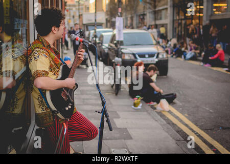 London, UK - Februar, 2019. Straßenmusiker spielt die Gitarre in der Brick Lane. Stockfoto