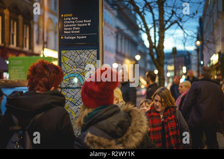 London, UK - Februar, 2019. Touristen auf der Suche nach Informationen in Central London in der Nähe von Covent Garden. Stockfoto