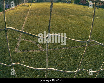 Fußball oder Football Ecke durch Net. Ansicht von hinter der Tribüne net mit unscharfen Stadion und Feld pitch Stockfoto