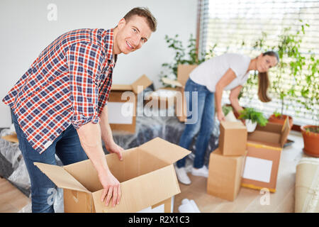 Junges Paar Auspacken der Kartons in die neue Wohnung nach dem Umzug Stockfoto