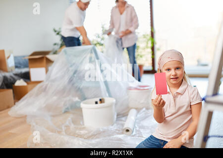 Mädchen hilft mit Malerei, mit Wandfarbe in Rosa für Zimmer Design Stockfoto