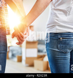 Glückliches Paar, während Sie die Hände im neuen Haus Stockfoto