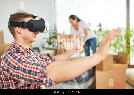 Junger Mann mit Virtual reality Brillen in der neuen Wohnung oder im neuen Haus Stockfoto