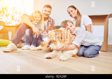 Glückliche Familie mit zwei Kindern und Hund um eine neue Familie zu Hause bewegen Stockfoto