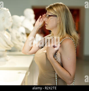 Frau mit schlechtem Sehvermögen Besuch Museum und das Betrachten der Bilder durch Gläser Stockfoto