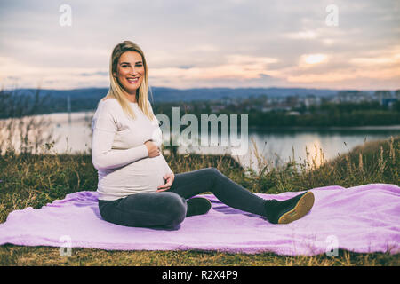 Schöne schwangere Frau genießt die Zeit im Freien. Stockfoto