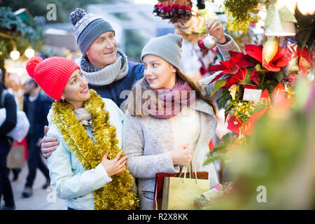 Freundliche Familie von drei Wahl Weihnachten Stern Blume am Weihnachtsmarkt Stockfoto
