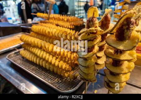 Eine strasse Garküche in Myeongdong in Seoul, Südkorea verkaufen frittierte Kartoffel Spiralen auf Holz- scewers. Stockfoto