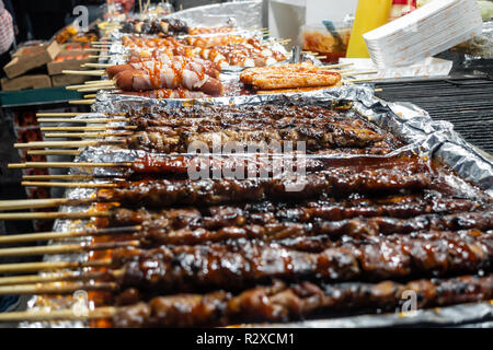 Gegrilltes Schweinefleisch Kebab und Würstchen auf Holzspieße auf Verkauf an einer Garküche in Myeongdong in Seoul, Südkorea. Stockfoto