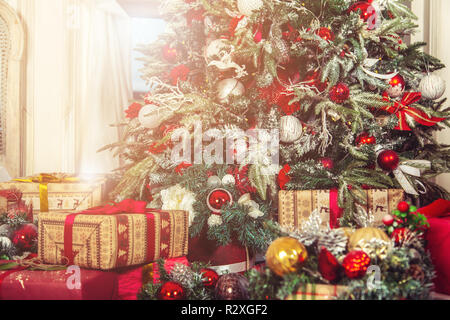 Weihnachtsbaum in einem hellen Wohnzimmer mit Geschenken und Weihnachtskugeln. Weihnachtsschmuck. Stockfoto