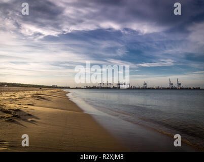 Lange leer sauberen Sand Stogi Strand in Danzig, Polen mit Stalin Werft mit Kränen im Hintergrund Stockfoto