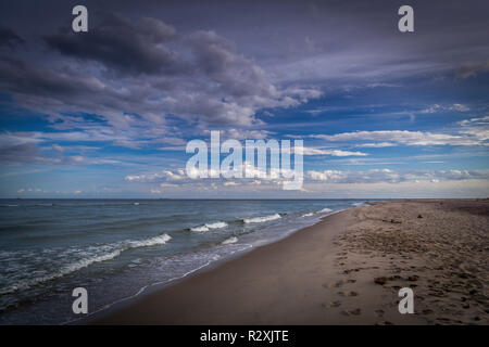 Lange leere Sandstrand auf der Halbinsel Hel in Polen mit dramatischen, bewölkt blauer Himmel Stockfoto