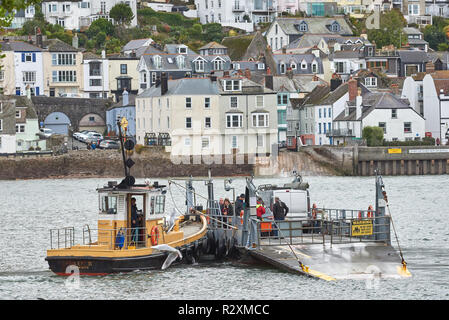 Fußgänger und Fahrzeuge der unteren Fähre und Schlepper Boot auf dem Fluss Dart zwischen Dartmouth und Kingswear, Devon, England. Stockfoto