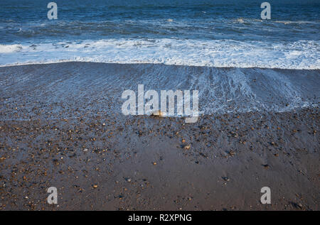 Eine Nahaufnahme von einem Strand mit Kiesel und Steine mit der Ebbe, England, Großbritannien Stockfoto