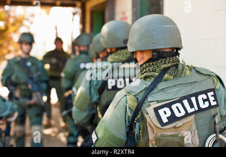 Team von bewaffneten militärischen Polizei holding Guns beim zusammen wandern in einer Linie. Stockfoto