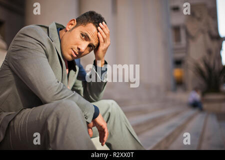 Junge Unternehmer auf der Suche besorgt, während draußen sitzen. Stockfoto