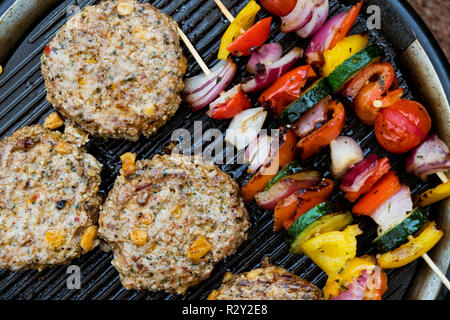 Essen auf einem Grill, Gemüse Kebabs und hausgemachten Burger, Kochen im Freien. Stockfoto