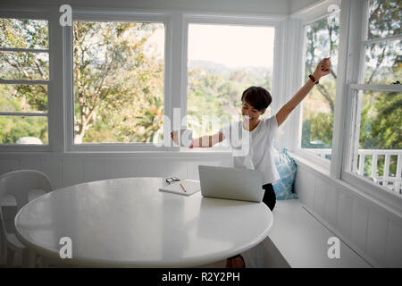 Junge Frau von zu Hause aus arbeiten. Stockfoto