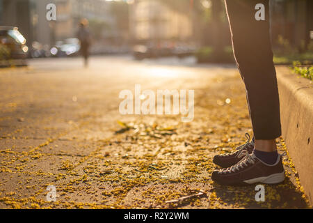 Herbst Szene, die Beine der Frau mit unscharfen Person in der Ferne verschwinden, geringe Tiefenschärfe Stockfoto