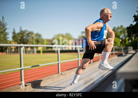 Ältere Menschen, die sich vor einem Rennen an einem Sportplatz. Stockfoto