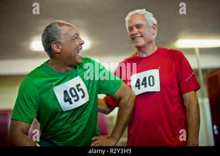 Ältere Männer lachen und scherzen in der Umkleide. Stockfoto