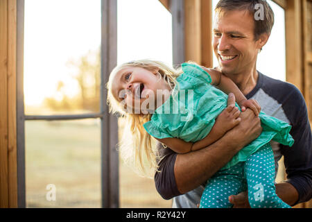 Verspielte Junge sein baby Bruder entlang ziehen in einem Wagen. Stockfoto