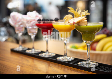 Eine Reihe von verschiedenen farbigen Smoothies in Gläsern auf hölzernen Hintergrund. Gesund Essen an der Bar Stockfoto