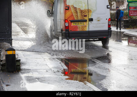 Autofahrer zu schnell gefahren durch grosse Pfützen einweichen Fußgänger und Unterkunft in Ambleside, Cumbria, Großbritannien. Stockfoto