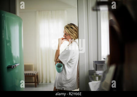 Frau trinkt Kaffee in der Küche. Stockfoto